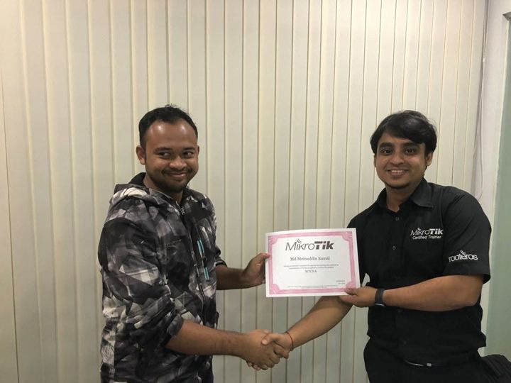 Trainer handing an MTCNA certificate to a smiling student