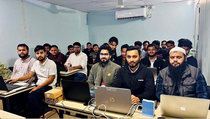 A large group of students seated at laptops in a training room